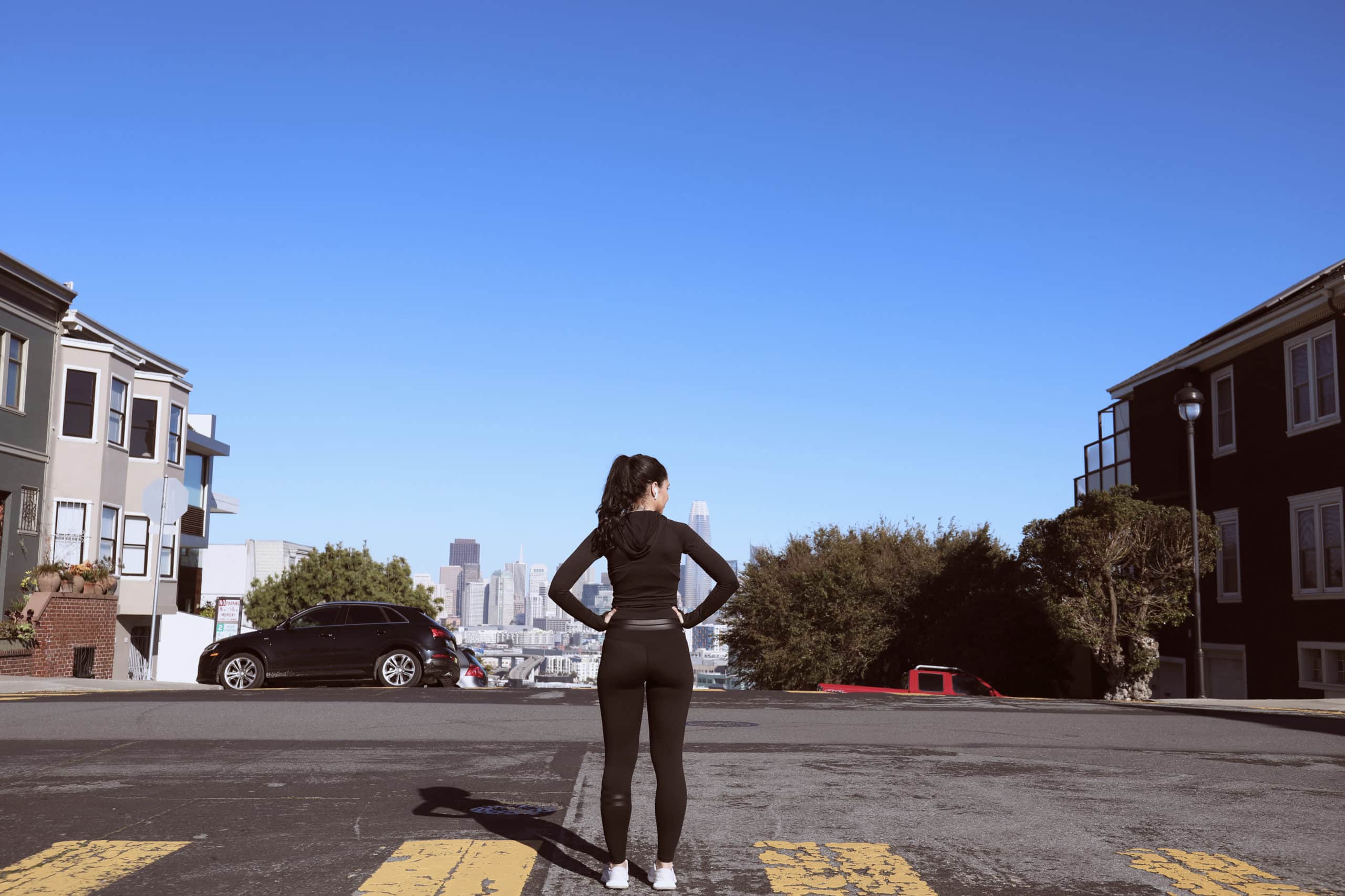 woman in workout clothes standing in the street